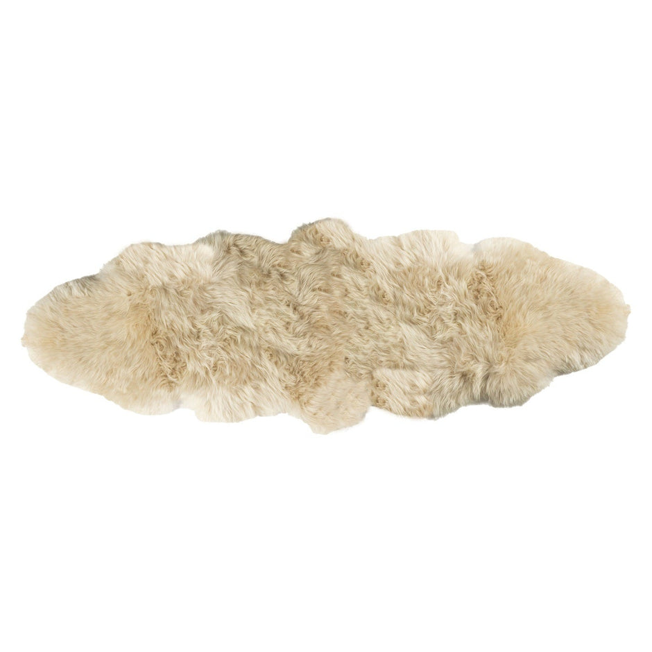 A beige-colored double longwool sheepskin rug laid out on a plain background.
