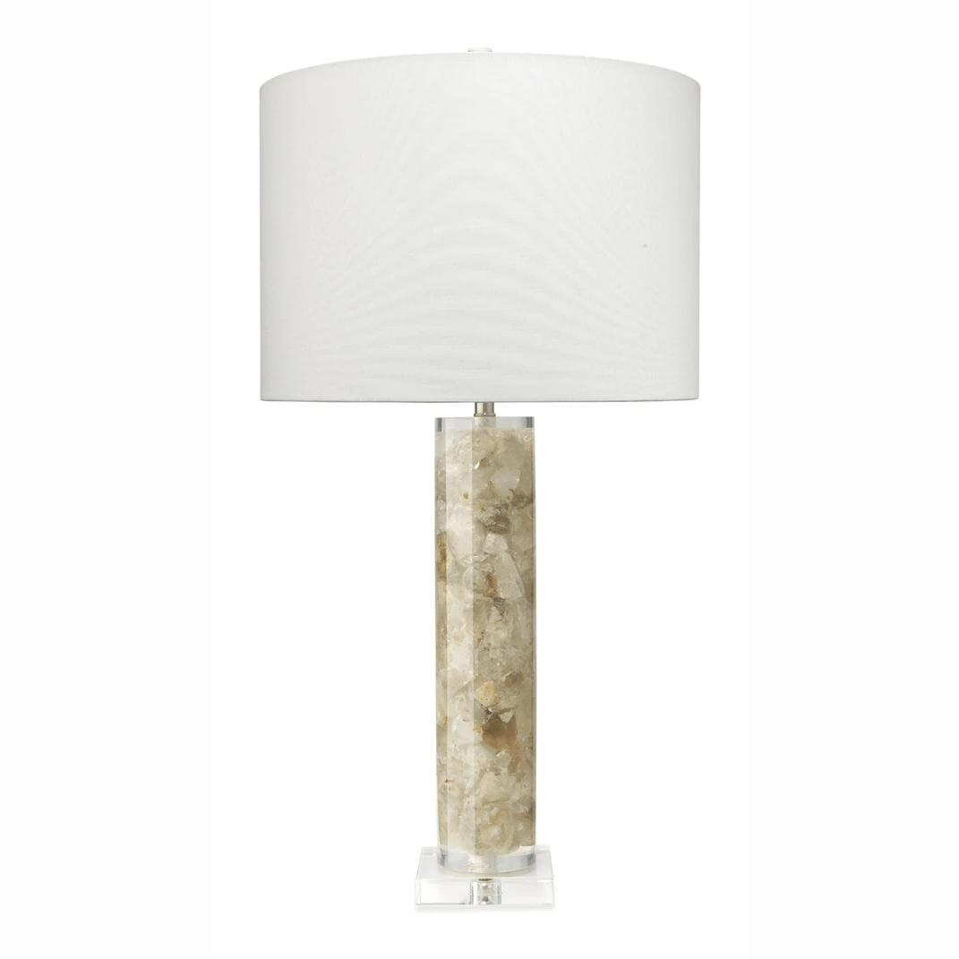 A table lamp with a natural calcite base and a white linen drum shade.