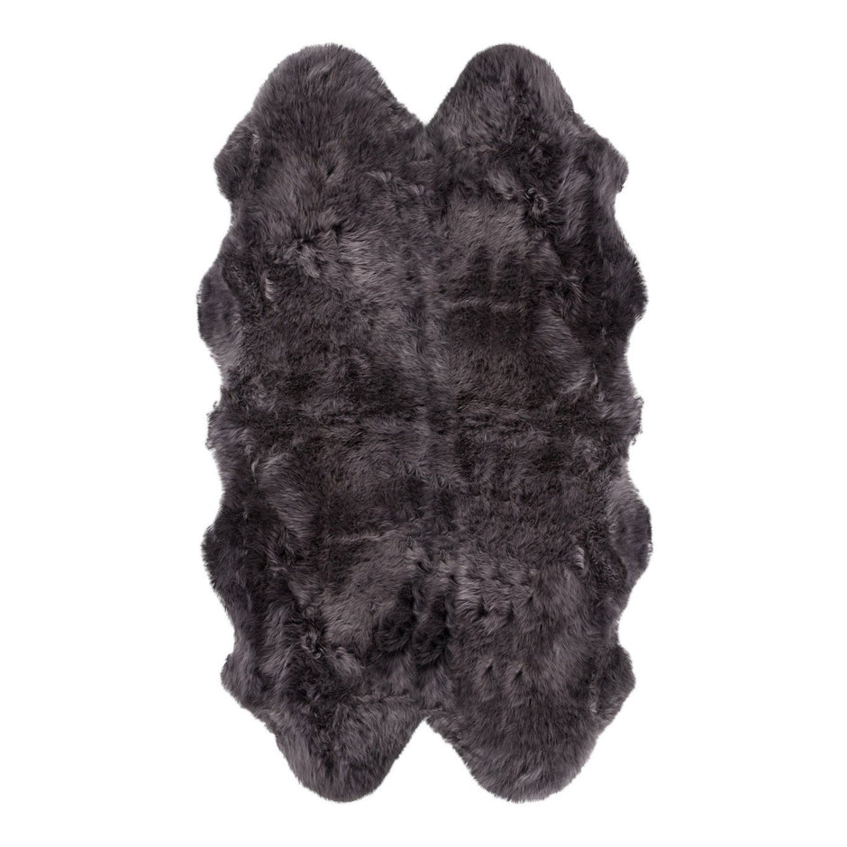 A natural-shaped black sheepskin rug