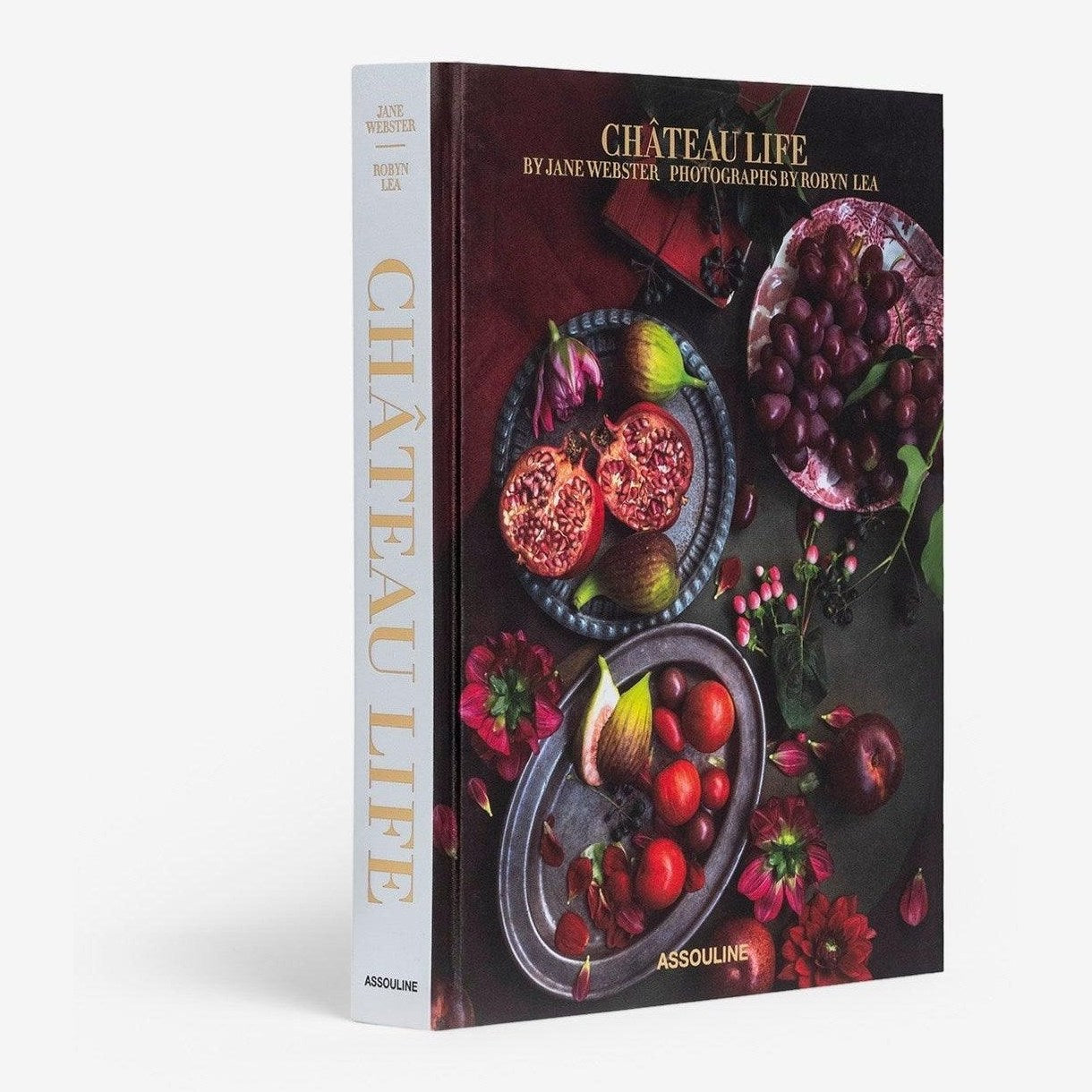 A book cover of 'Chateau Life' featuring a photograph of various food items like fruits and dishes, with a focus on a souffle dish.
