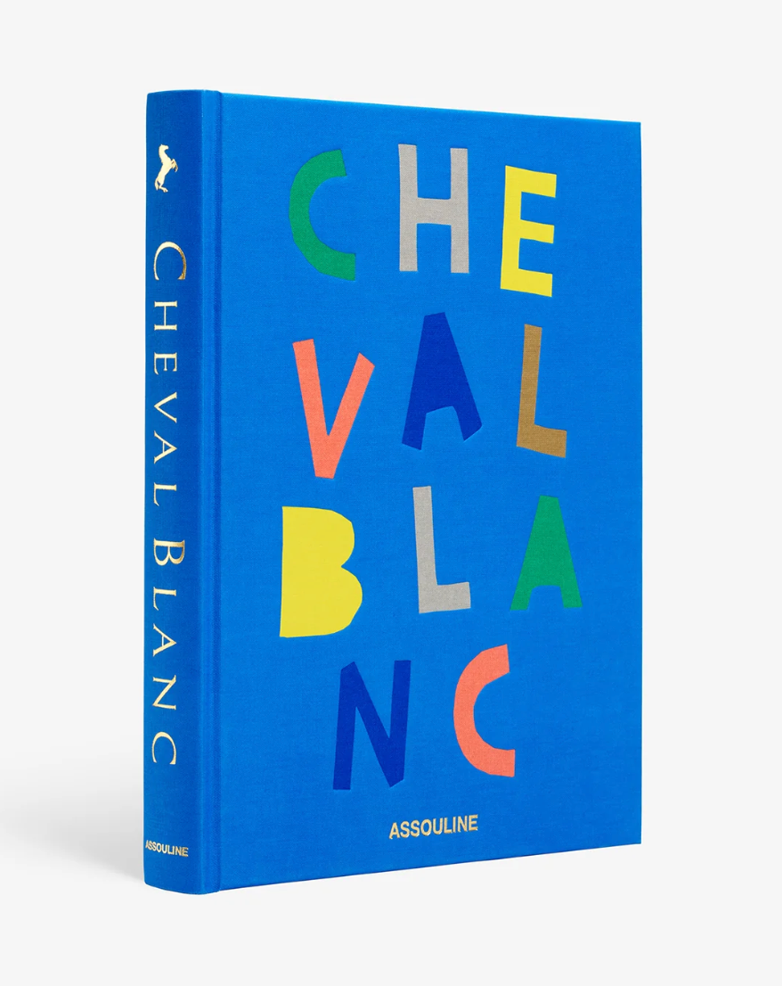 Blue book titled 'Cheval Blanc' with colorful text on a white background