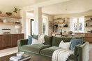 green sofa blue pillows cream throw in a room with natural wood accents