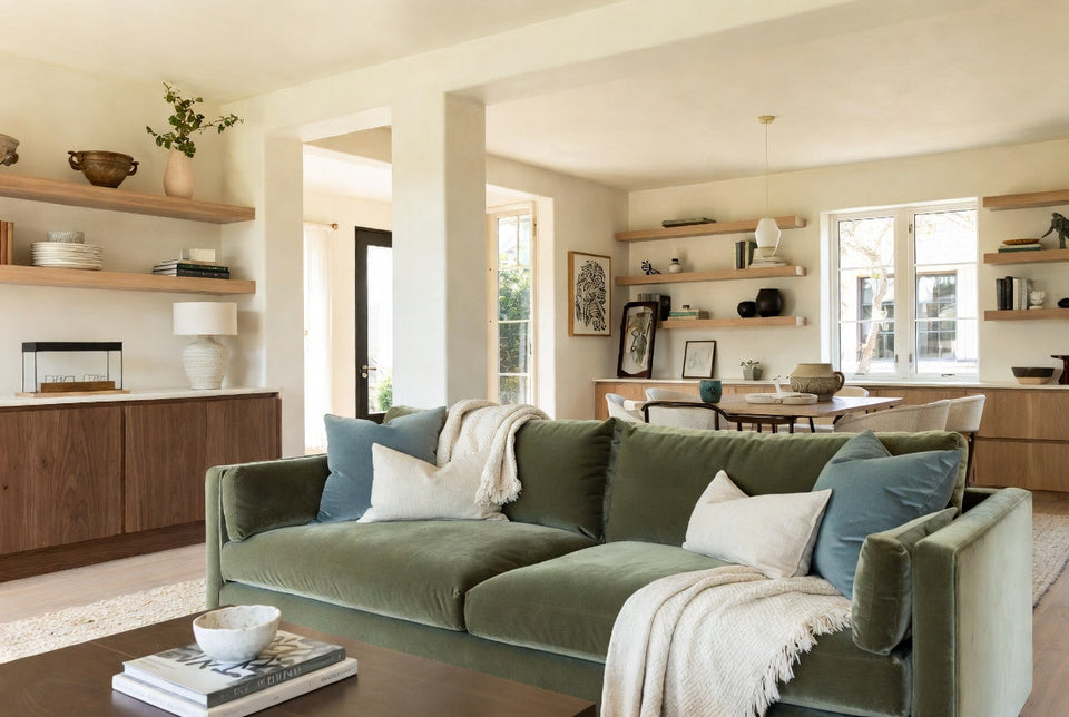 green sofa blue pillows cream throw in a room with natural wood accents