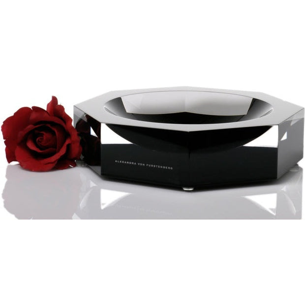 A solid acrylic bowl from the Alexandra Von Furstenberg Nut n Bowl collection, displayed with a red rose beside it, reflecting a sophisticated and colorful aesthetic.