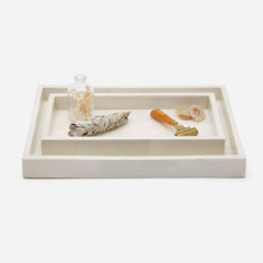 A white rectangular tray with a faux horn pattern, displayed with decorative items on it.