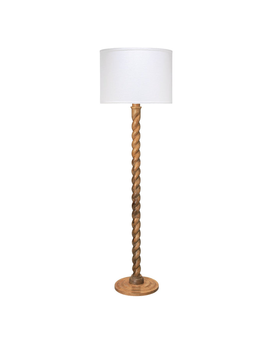 A floor lamp with a white drum shade, a twisted wooden central stem, and a round wooden base, shown against a plain white background.