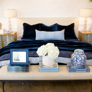 Neatly arranged bedroom with a bed, nightstands, and decorative items.