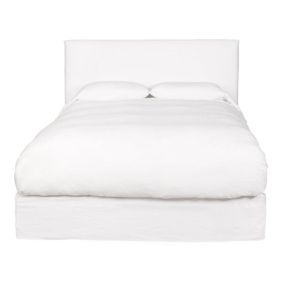 A king-sized white leather bed frame with a headboard and footboard, presented in an unmade state showcasing the mattress and pillows.