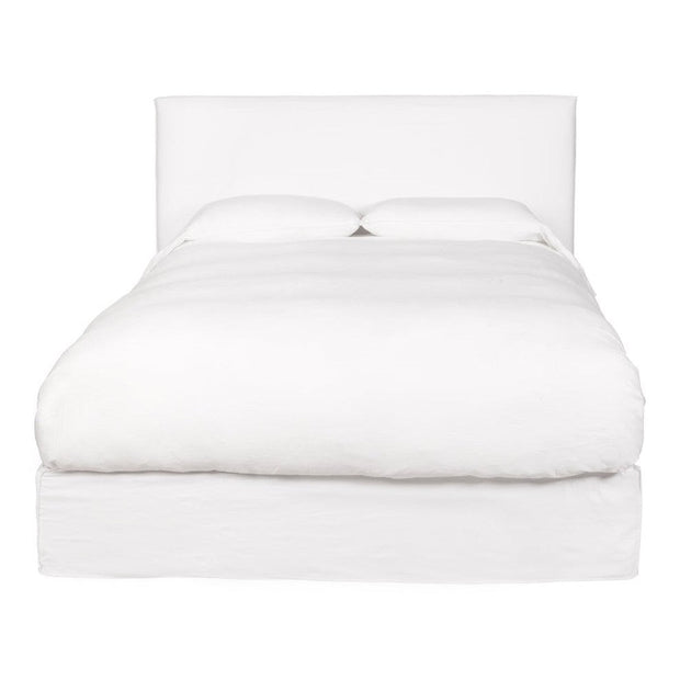 A king-sized white leather bed frame with a headboard and footboard, presented in an unmade state showcasing the mattress and pillows.