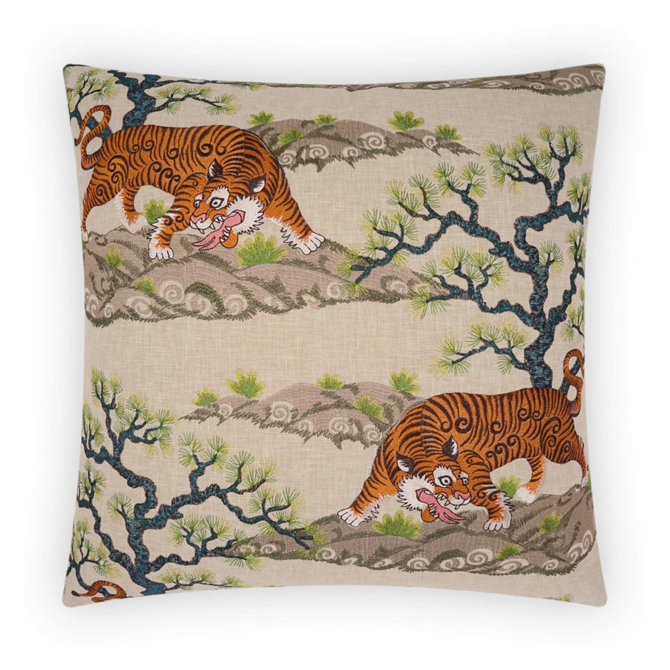 A square decorative pillow with a beige background featuring embroidery of a chonburi scene with trees and a tiger.