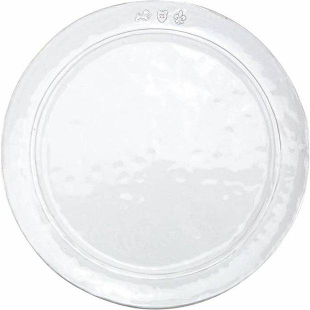 A white, round, ceramic dinner plate with subtle texture patterns.