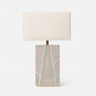 A rectangular table lamp with a beige shade, featuring a geometric patterned base in shades of gray and white, topped with a gold accent.