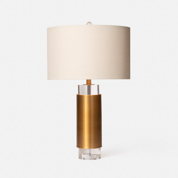 A table lamp with a brass base, clear crystal column, and a white lampshade.
