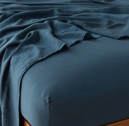 A flat blue sheet on a bed, showcasing its color and texture.