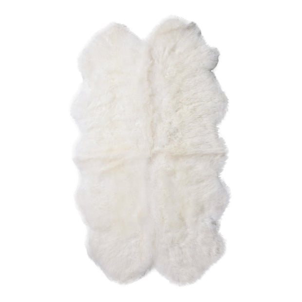 A natural-shaped white sheepskin rug
