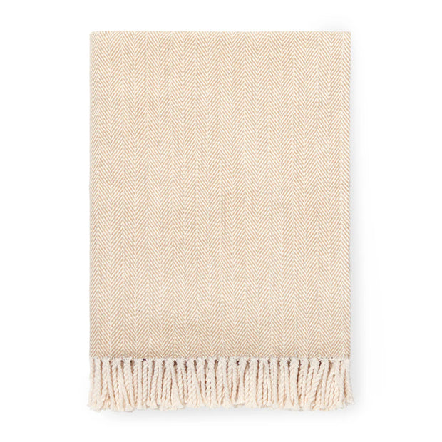 Beige woven blanket with fringes on a white background