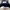 A luxurious dark blue silk velvet coverlet with a quilted pattern and satin edge, displayed on a bed with white and light blue bedding.