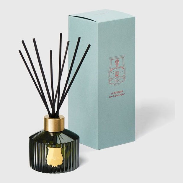 A 350ml Trudon diffuser with black reeds and a gold cap, alongside its blue packaging box featuring the Trudon logo.