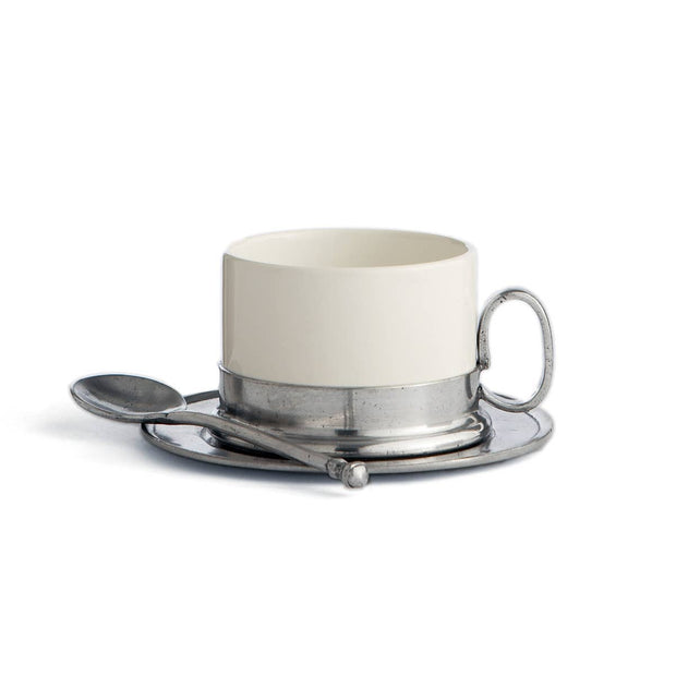 A white ceramic cappuccino cup with a silver-handled spoon and a silver saucer, representing the Tuscan collection.