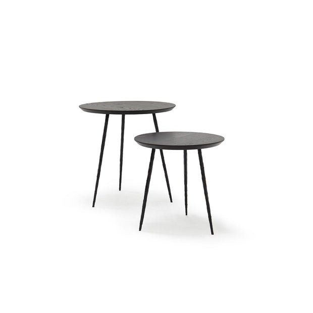 Two round walnut nesting tables with hand-hammered steel legs, one larger than the other, on a white background.