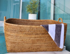 Honey brown rattan everything basket with hoop handles, crafted by Artifacts Trading Company for versatile storage.