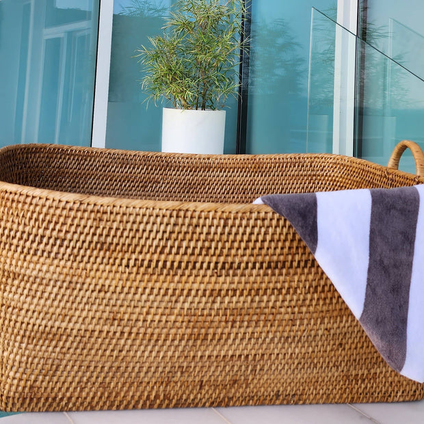 Honey brown rattan everything basket with hoop handles, crafted by Artifacts Trading Company for versatile storage.