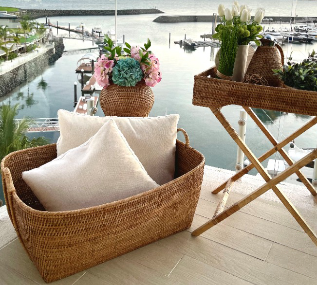 Honey brown rattan everything basket with hoop handles, woven from Artifacts Trading Company for storage and organization.