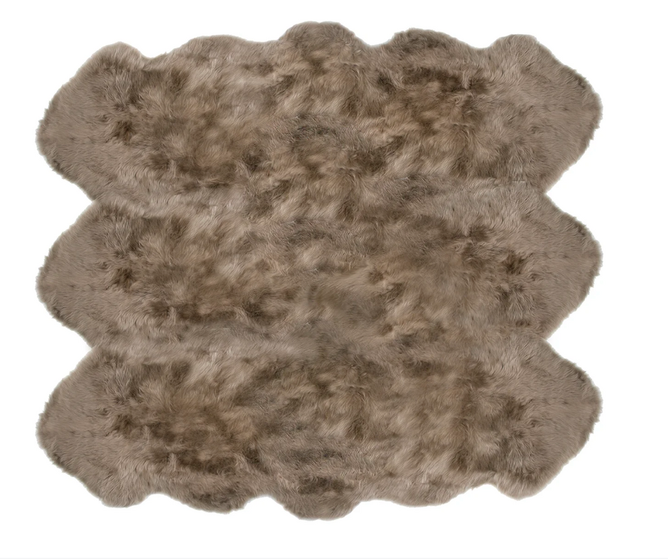 Taupe Auskin Sexto Longwool Sheepskin Rug laid on a neutral surface, showcasing its soft, plush texture and natural wool fibers.