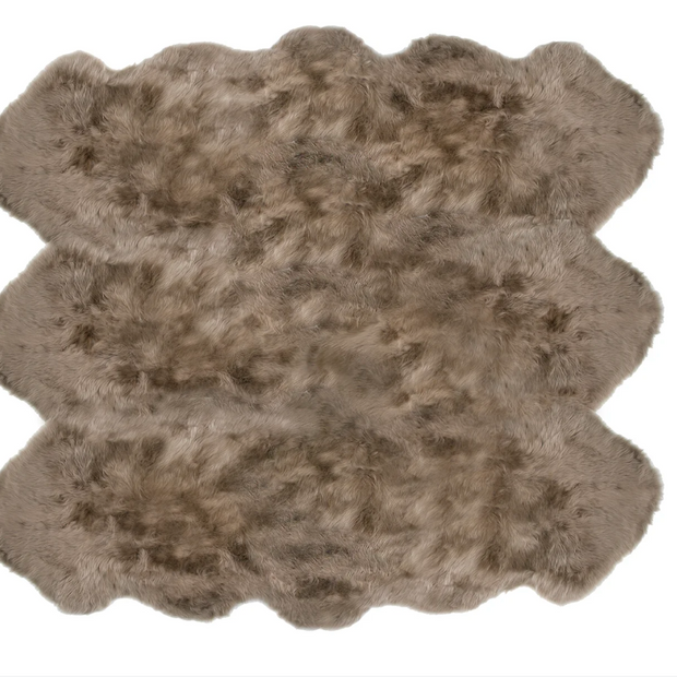 Taupe Auskin Sexto Longwool Sheepskin Rug laid on a neutral surface, showcasing its soft, plush texture and natural wool fibers.