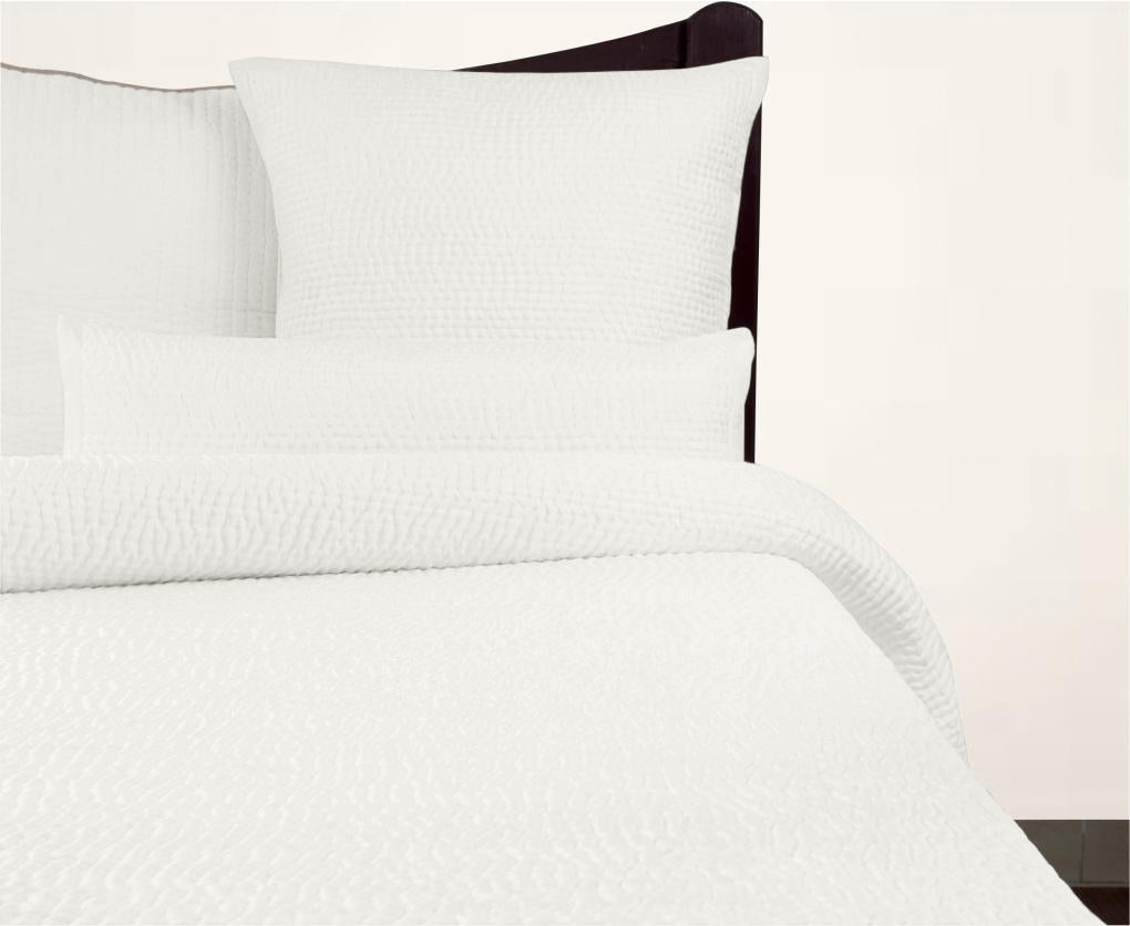 Cream Avasa Katherine quilt spread with intricate stitching, neatly folded to showcase its soft, luxurious fabric and elegant design.