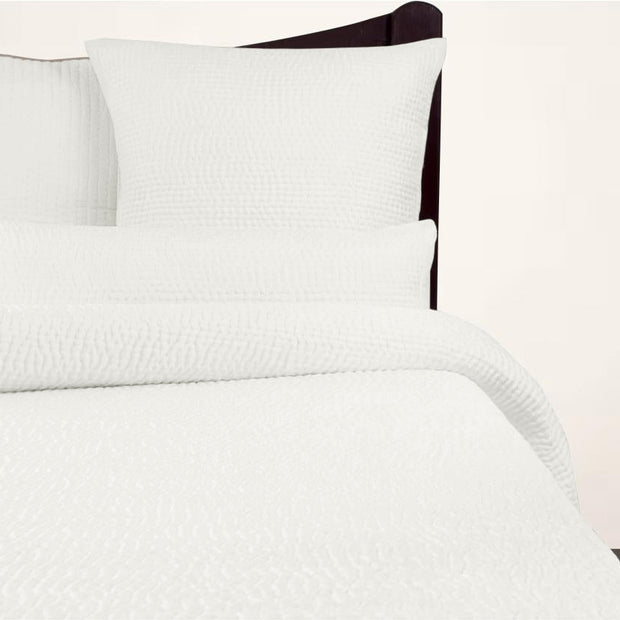 Cream Avasa Katherine quilt spread with intricate stitching, neatly folded to showcase its soft, luxurious fabric and elegant design.