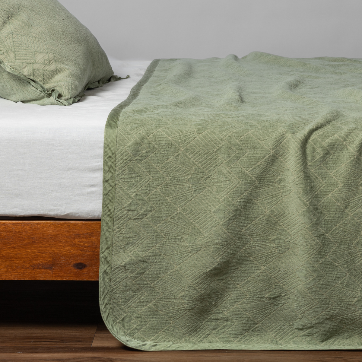 Bella Notte Trettino bedspread in autumn colors, neatly spread on a bed, showcasing its elegant, soft fabric and intricate design.