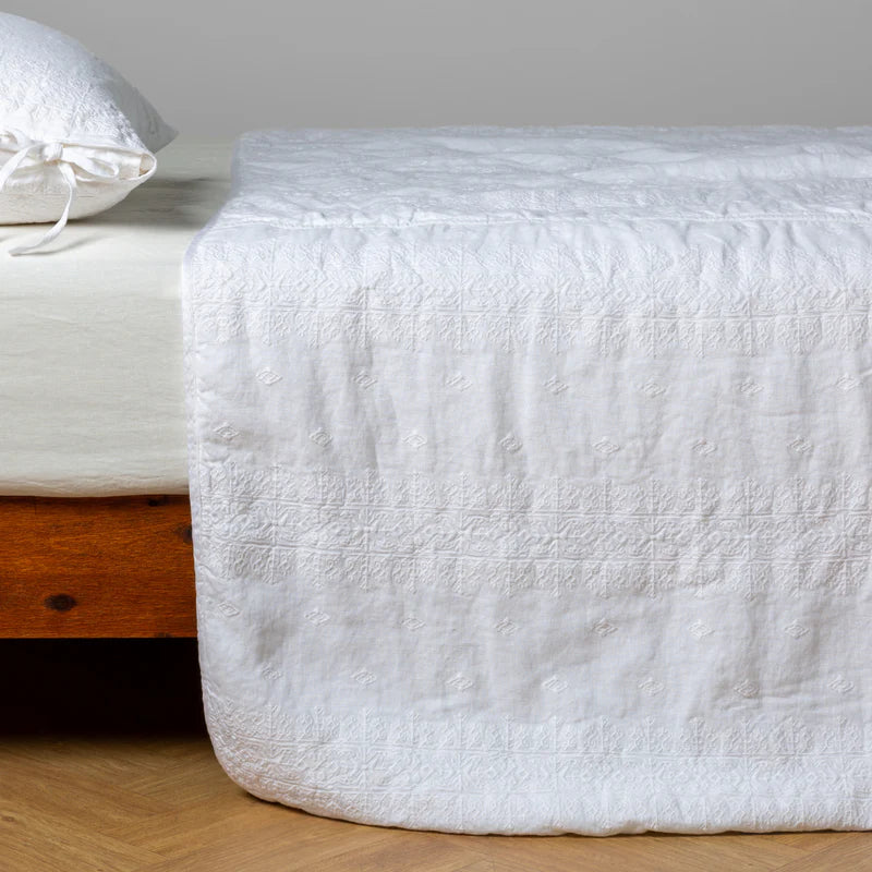 White Bella Notte Ines Bedspread spread over a king-size bed, showcasing elegant, soft fabric and detailed stitching.