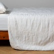 White Bella Notte Ines Bedspread spread across a bed, showcasing soft, luxurious fabric and elegant design for a king-sized bed.