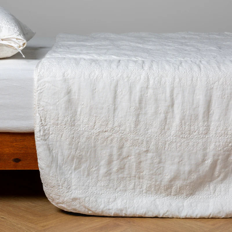 White Bella Notte Ines Bedspread spread across a bed, showcasing soft, luxurious fabric and elegant design for a king-sized bed.