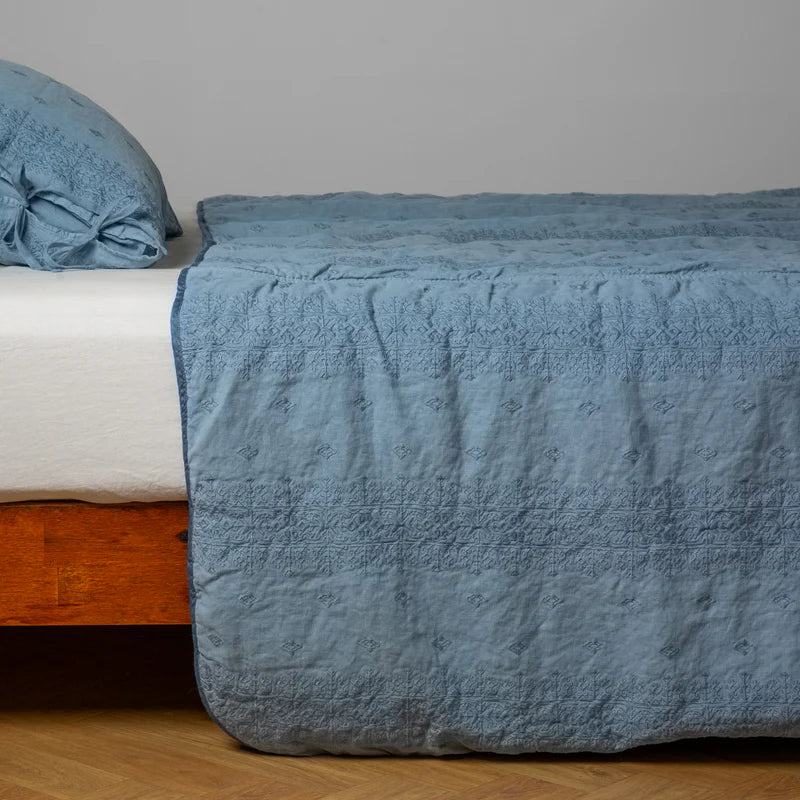 White Bella Notte Ines Bedspread spread across a bed, showcasing elegant, luxurious bedding with subtle texture and refined design.