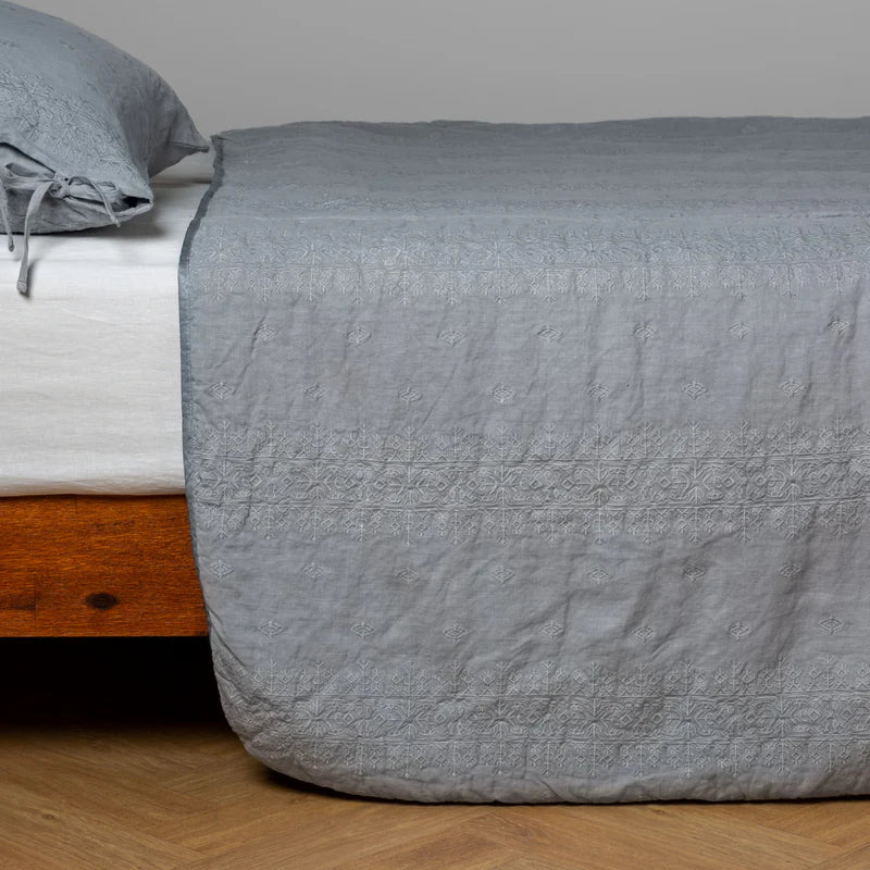 White Bella Notte Ines Bedspread spread smoothly on a king-sized bed, showcasing soft fabric and elegant design details.