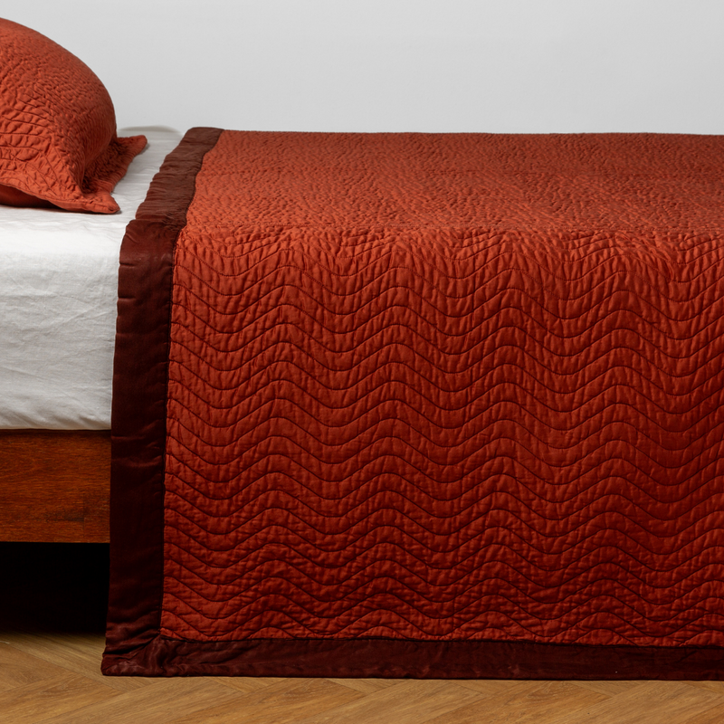 Bella Notte Cirillo Coverlet in autumn colors, showcasing soft fabric and elegant design on a bed.
