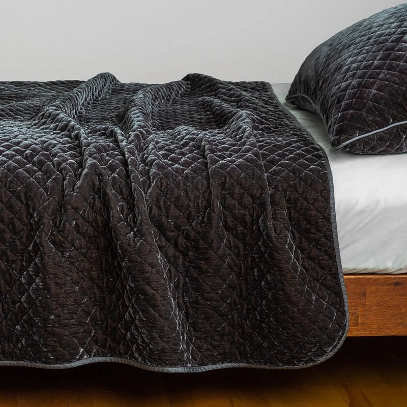 Bella Notte silk velvet quilted coverlet in a rich autumn color, showcasing its luxurious, quilted texture on a cozy bed.