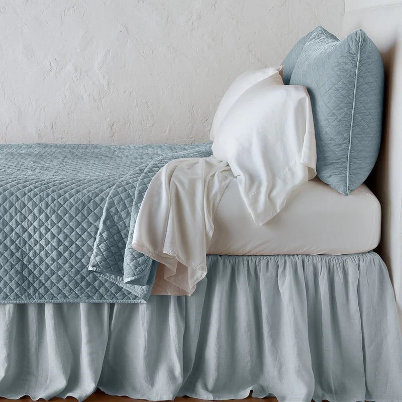 Bella Notte silk velvet quilted coverlet on a bed, showcasing its luxurious texture and elegant autumn color.