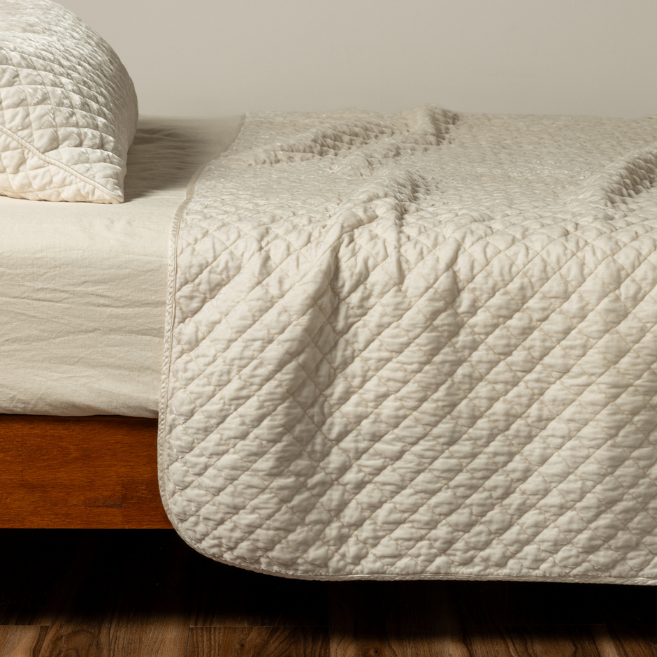 Cream silk velvet quilted coverlet by Bella Notte, showcasing plush texture and elegant stitching on a luxurious bedding piece.