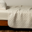Cream silk velvet quilted coverlet by Bella Notte, showcasing plush texture and elegant stitching on a luxurious bedding piece.