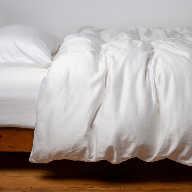 White Bella Notte Seraphina duvet cover on a queen bed, showcasing elegant, soft fabric with detailed stitching.