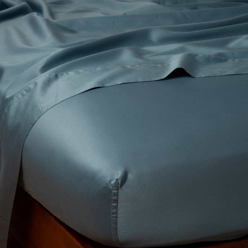 Bella Notte Bria fitted sheet in Cenote color, luxurious cal king size, soft and smooth bedding fabric, close-up of the fitted sheet.