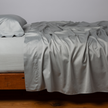 Bella Notte Cenote King Bria Flat Sheet spread out on bed with soft, luxurious fabric and intricate stitching details.
