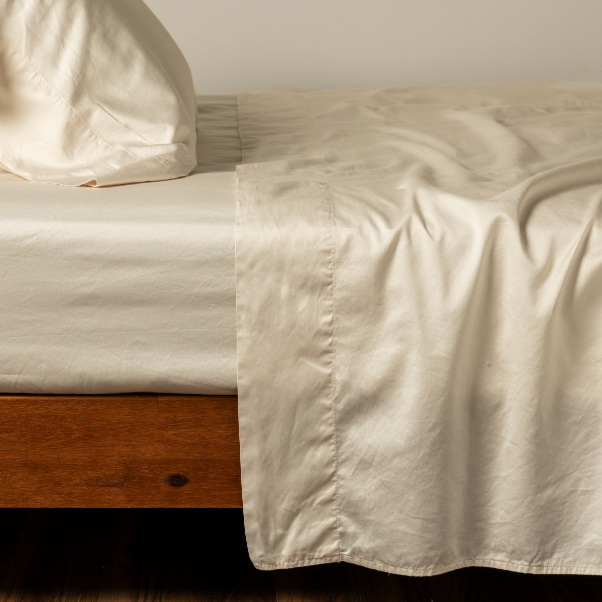 Bella Notte Bria flat sheet in natural color, showing smooth fabric and clean edge details on a neatly made bed.