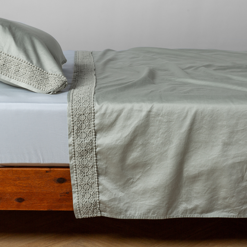 Bella Notte Bria flat sheet in Cenote with Novola lace, showcasing soft fabric and elegant lace detailing for a luxurious bedroom look.