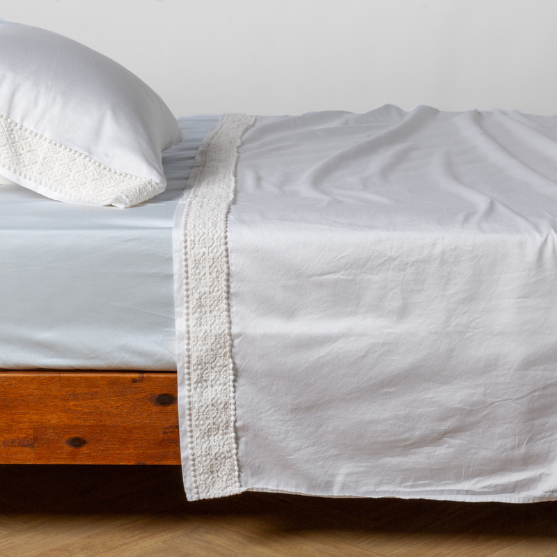 Bella Notte Bria flat sheet in Cenote with Novola lace, showing soft fabric and delicate lace trim on a neatly made bed.