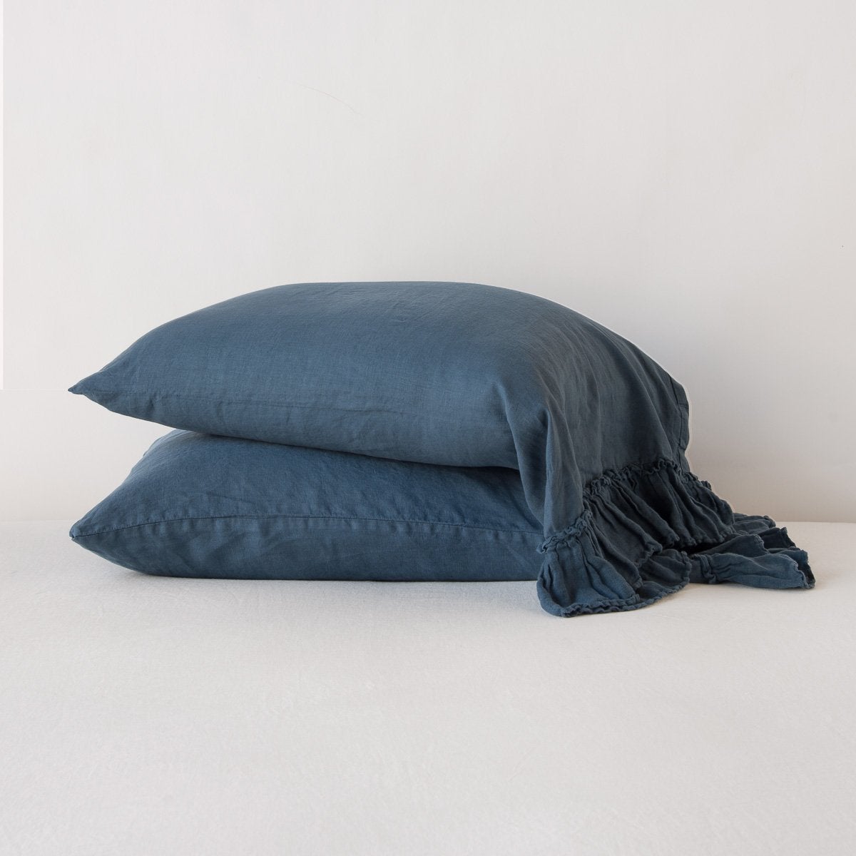 White Bella Notte Linen Whisper pillowcase on a bed, showcasing soft, textured fabric and elegant design in a standard size.