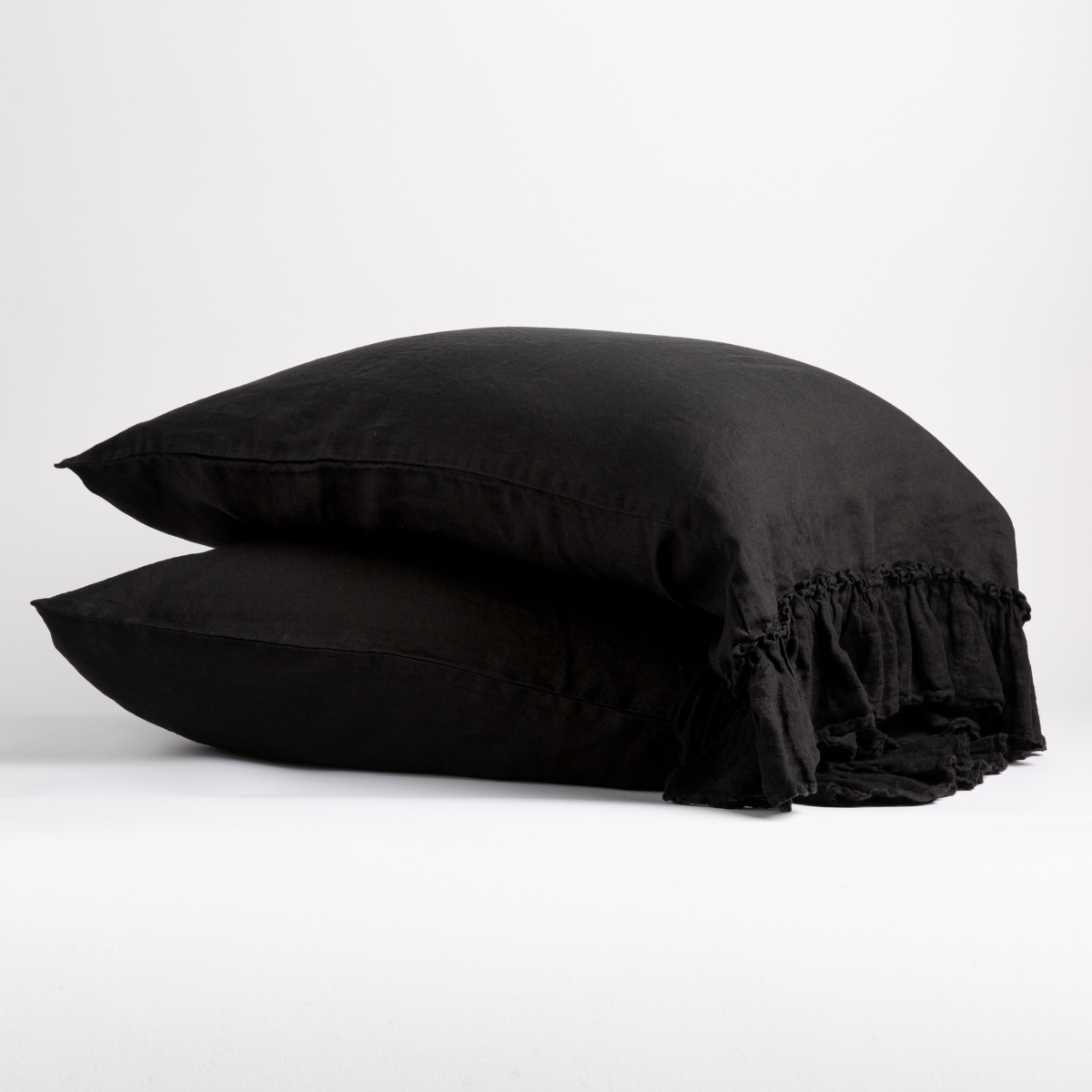 White Bella Notte Linen Whisper pillowcase on a bed, showing soft, crisp fabric and elegant stitching for a cozy, luxurious look.